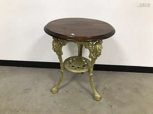 A vintage café table, cast iron gilt painted base with circular wooden top, 58cm diameter x 70cm