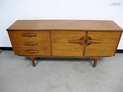 A Mid - Century teak veneered sideboard, double cupboard to one side and three drawers to the other,