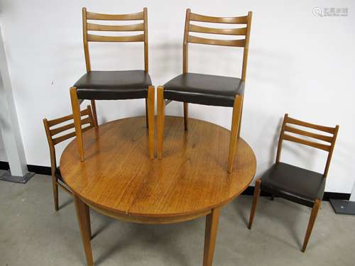 A Mid - Century teak veneered dining table and chairs, circular drawer leaf table with pop up