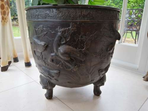 A bronzed cast early 20th Century jardinière, raised on four mythical beast feet, with continuous