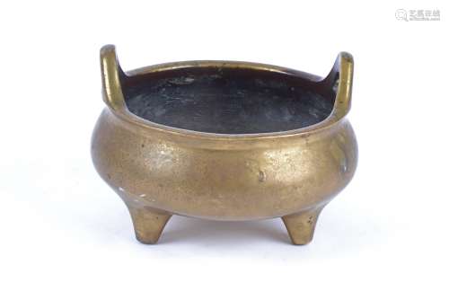A Chinese bronze tripod censer, of compressed globular body supported on three tapering feet with