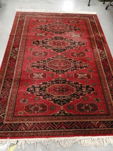 A Belgian Royal Keshan rug, on a red ground with four foliated shapes containing octagons, with