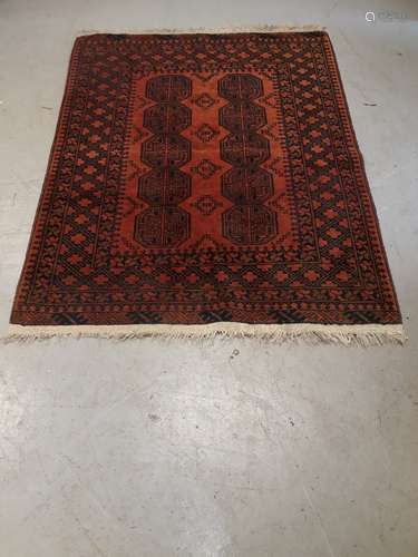 Old Middle Eastern Rug, a bordered geometric patterned red ground example with ten octagonal