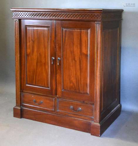 A 20th Century Hardwood Side Cabinet with two panel doors above two drawers raised upon a plinth