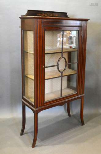 An Edwardian Mahogany Display Cabinet with an astragal glazed door enclosing shelves raised upon