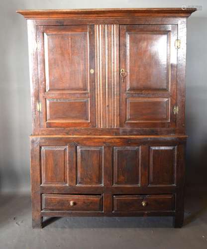 A George III Oak Bacon Cupboard, the moulded cornice above two moulded panel doors enclosing a