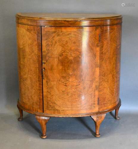 An Early 20th Century Burr Walnut Demi-Lune Side Cabinet, the moulded crossbanded top above a