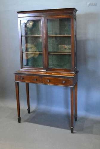 An Edwardian Mahogany Display Cabinet with two glazed doors enclosing shelves, the lower section