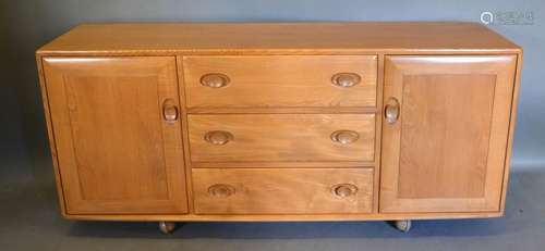 An Ercol Blonde Ash Sideboard with three central drawers flanked by cupboard doors with cup handles,