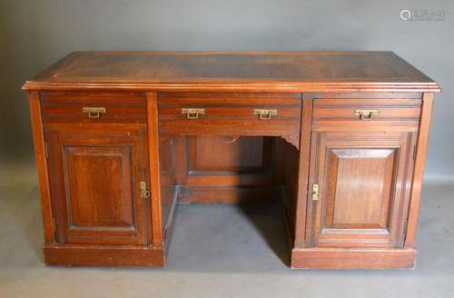 An Edwardian Twin Pedestal Desk with three drawers and two cupboard doors with brass handles