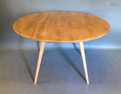 An Ercol Blonde Ash Drop Flap Dining Table of oval form raised upon square tapering splay legs,