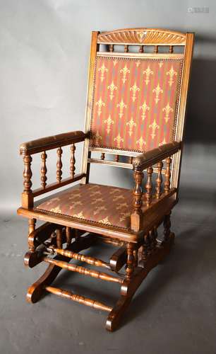 An American Walnut Rocking Chair with a Fleur-de-Lys upholstered back and seat raised upon shaped