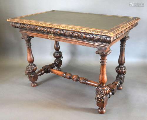 A Victorian Carved Oak Library Table, the leather inset top above a frieze drawer with brass handle,