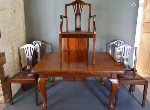 An Early 20th Century Walnut Wind Out Extending Dining Table with single extra leaf, together with a
