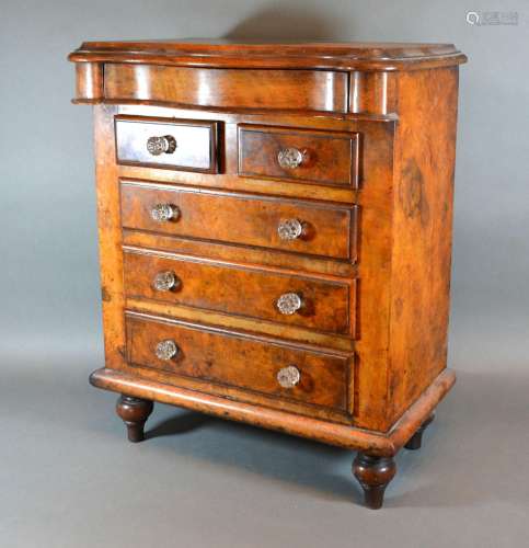 A Victorian Burr Walnut Apprentice Chest with a concealed frieze drawer above two short and three