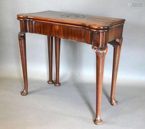 A George III Mahogany Card Table, the shaped hinged top above a plain frieze, raised upon turned