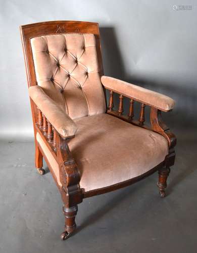 A Victorian Mahogany Drawing Room Armchair with button upholstered back above a stuff over seat