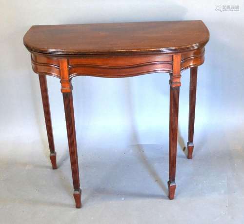 An Edwardian Mahogany Line inlaid Card Table with hinged reeded top above a shaped frieze, raised