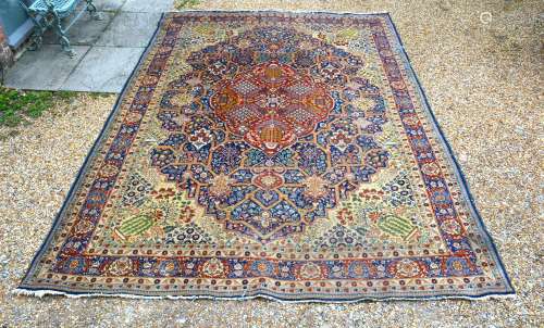 A North West Persian Woollen Carpet with a central medallion within an all-over design upon an
