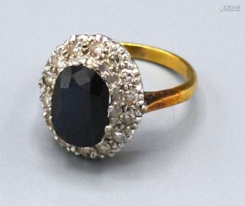 An 18ct. Gold Sapphire and Diamond Cluster Ring with an oval sapphire surrounded by diamonds