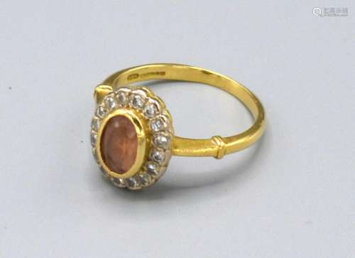 An 18ct. Gold Citrine and Diamond Cluster Ring with a central oval citrine surrounded by diamonds,