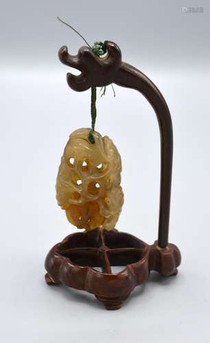 A 19th Century Jade Carving of Pierced Form with Hardwood Stand, the carving 5cm long, the stand