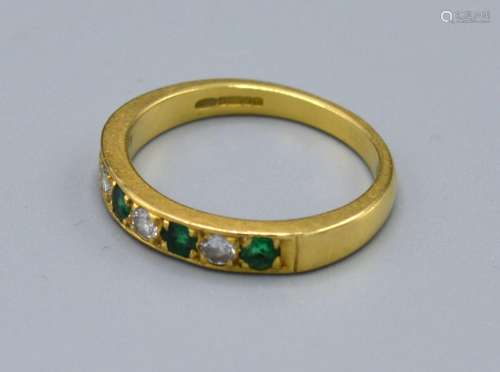 An 18ct. Gold Emerald and Diamond Band Ring set four emeralds and three diamonds, ring size N, 3.6