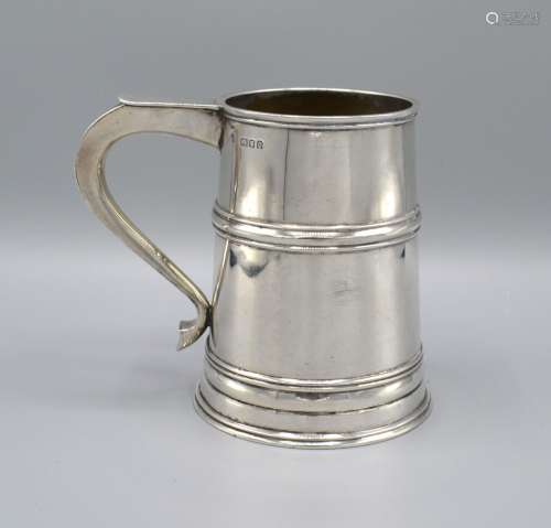 A London Silver Mug with shaped handle and waisted band Marked Harrods, 12oz, 12cm tall