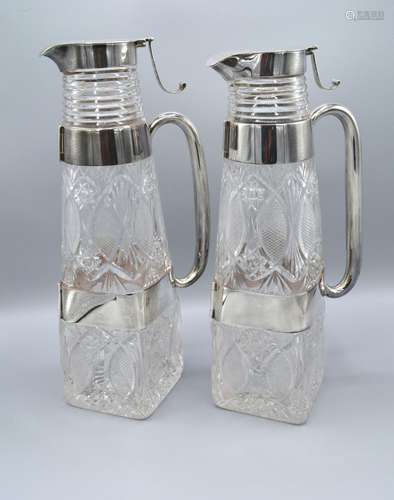 A Pair of Victorian Silver and Cut Glass Claret Jugs each with a double silver band and shaped