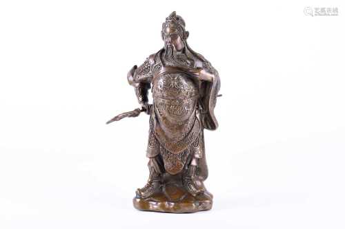 A Chinese bronze figure of Guandi, 20th century, modelled standing and tugging at his beard, dressed