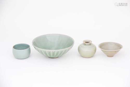 A Northern Song celadon tea bowl, 10th century, thinly potted and conical under a grey/green
