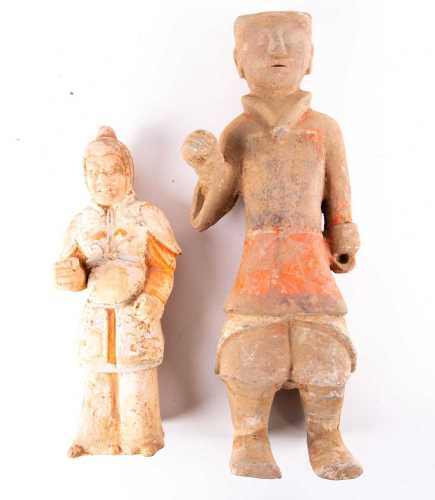 Two Chinese pottery tomb guardians, Tang dynasty, one modelled with a fierce expression, dressed