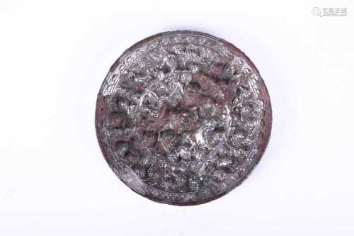 A Chinese silvered bronze circular 'lion and grapevine' mirror, Tang Dynasty, cast with a central