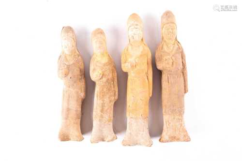 Two pairs of Chinese pottery standing figures, Tang dynasty, each modelled with their right hand