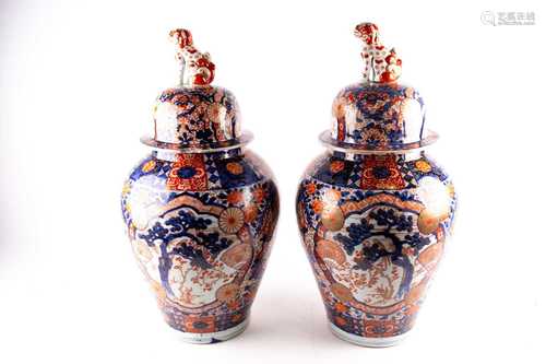 A pair of large Arita imari vases and covers, mid 19th century, each baluster body densely decorated