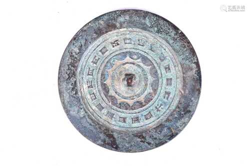 A Chinese bronze mirror, Han Dynasty (206BC - 220AD), with central pierced boss framed by plain