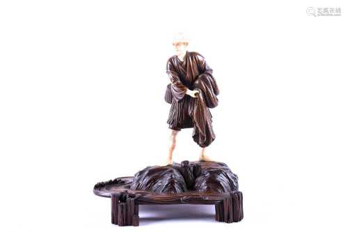 A Japanese carved wood and ivory figure of a fisherman, Meiji period, the well carved figure