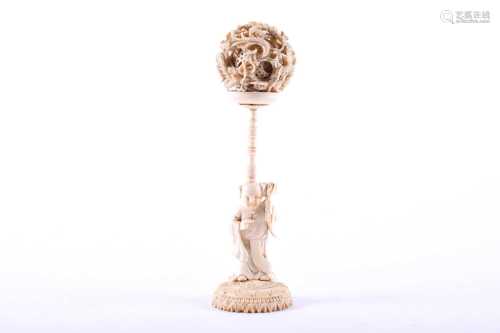 A Chinese ivory puzzle ball on stand, late 19th century, the outer ball carved with three dragons