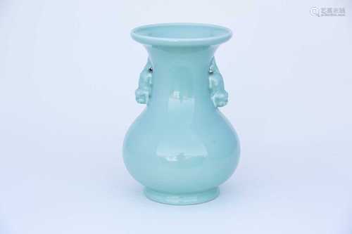 A Chinese celadon baluster vase, the neck with applied buddhist lion handles, on a circular foot,