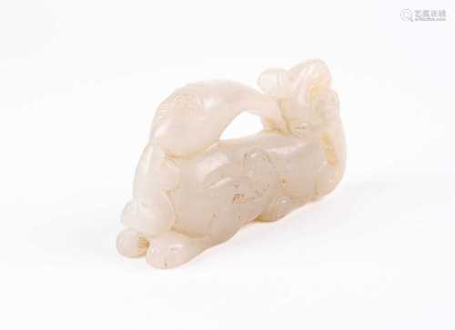 A Chinese jade carving of a mythical beast, 20th century, the recumbent beast with scrolls on its