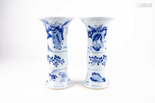 A pair of Chinese blue & white Gu form vases, 19th century, the flaring rims above a dignitary and