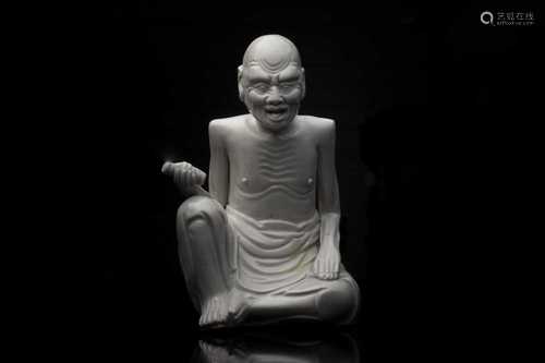 A Chinese blanc de Chine figure of an emaciated Luohan, Qing Dynasty, modelled seated in his robes