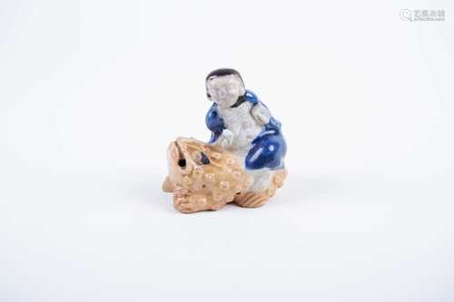 A rare Chinese porcelain water dropper modelled as Liu Hai riding upon the mythical three legged