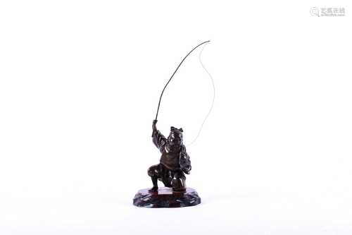 A Japanese bronze figure of Ebisu, Meiji period, naturalistically modelled landing a fish, on wood