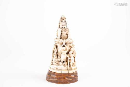 A Japanese ivory okimono, Meiji period, well carved as a startled deity seated in a lotus leaf