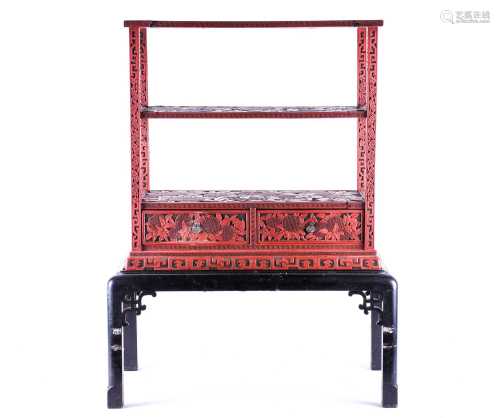 A late 19th century Chinese red cinnabar lacquer shelf unit on stand, deeply carved in relief with