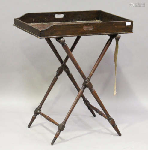 A late Victorian oak butler's tray, length 75cm, depth 50cm, raised on a folding stand.Buyer’s