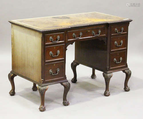 A George V mahogany inverted breakfront writing desk, the top inset with leather above an