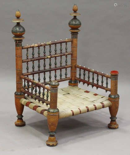 A late 19th/early 20th century Indian painted and turned wooden wedding chair with woven strap seat,