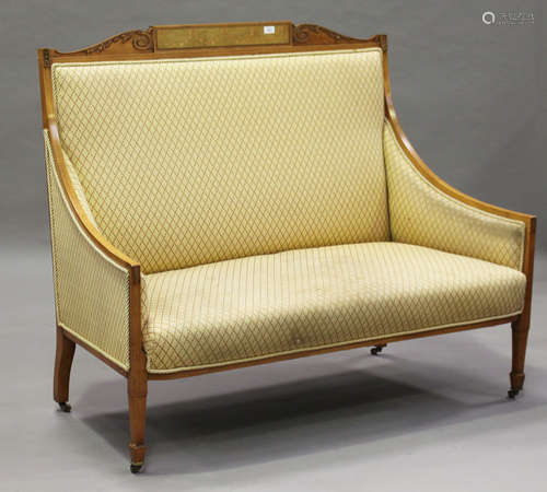 An Edwardian Neoclassical Revival satinwood showframe salon settee, the frame finely carved with